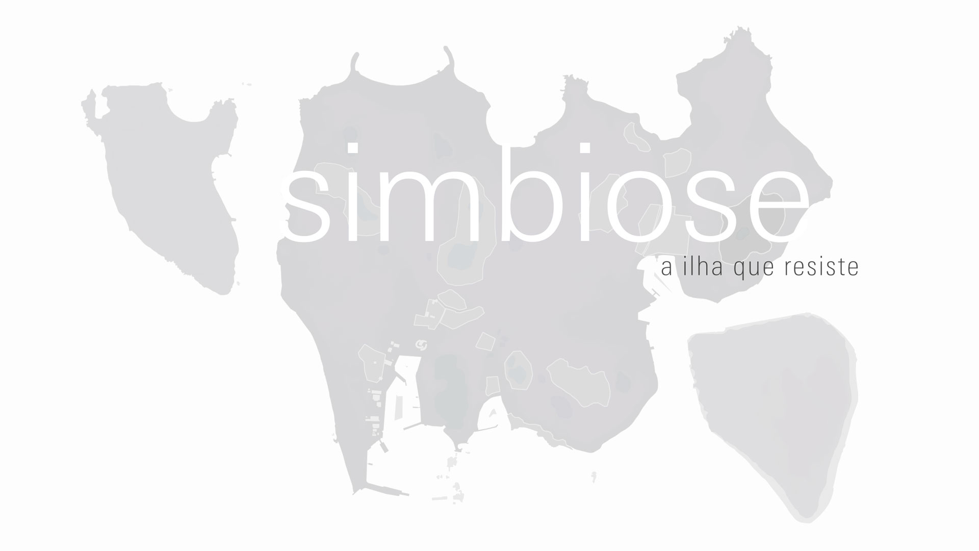 Sobre fundo branco o mapa da Ilha de Inujima na cor cinza e sobre ele o título da exposição: Simbiose, a Ilha que Resiste. A palavra Simbiose está escrita com letras minúsculas brancas, e a frase: A Ilha que Resiste com letras minúsculas menores na cor preta.